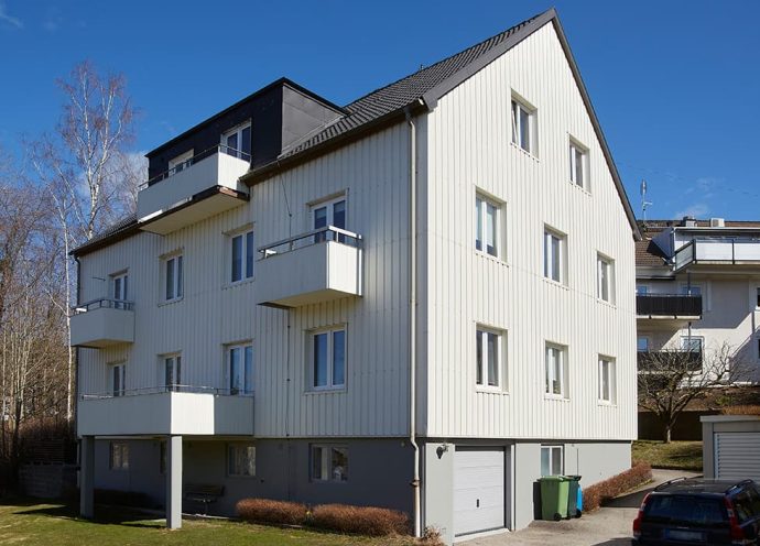 Exteriör bild av fastigheten Blåvalen på Stenkilsgatan, Norrmalm, Borås. Vitt plåtbeklätt hus om 3 våningar med balkonger.