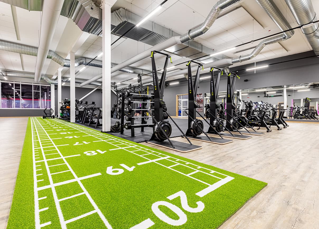 Bild från en av STCs klubbar. Flertalet gymmaskiner uppradare med en numrerad matta 1-20 på golvet.