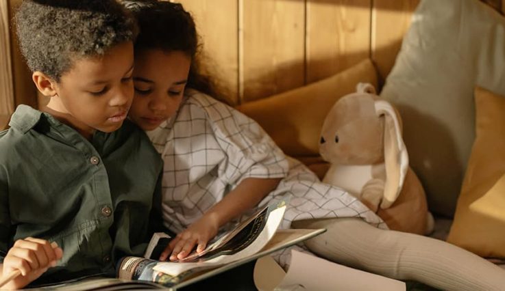 Två barn läser i en trygg hemmiljö