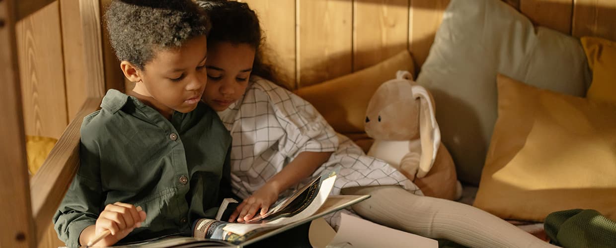 Två barn läser i en trygg hemmiljö