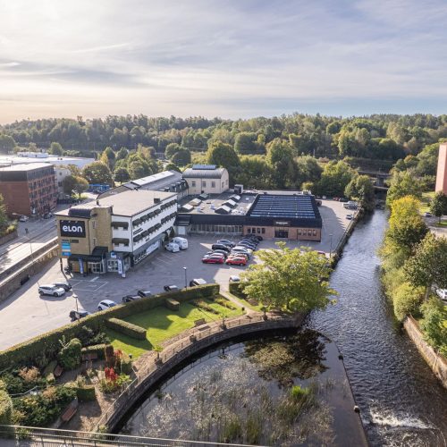 Drönarbild över fastigheten med Druveforsfallet främst i bild, och ån Viskan rinnande utanför fastigheten.