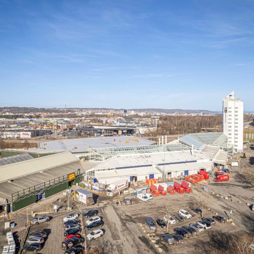 Drönarbild från fastighetens nya entrésida. Mycket parkeringar syns i anslutning till entréerna.
