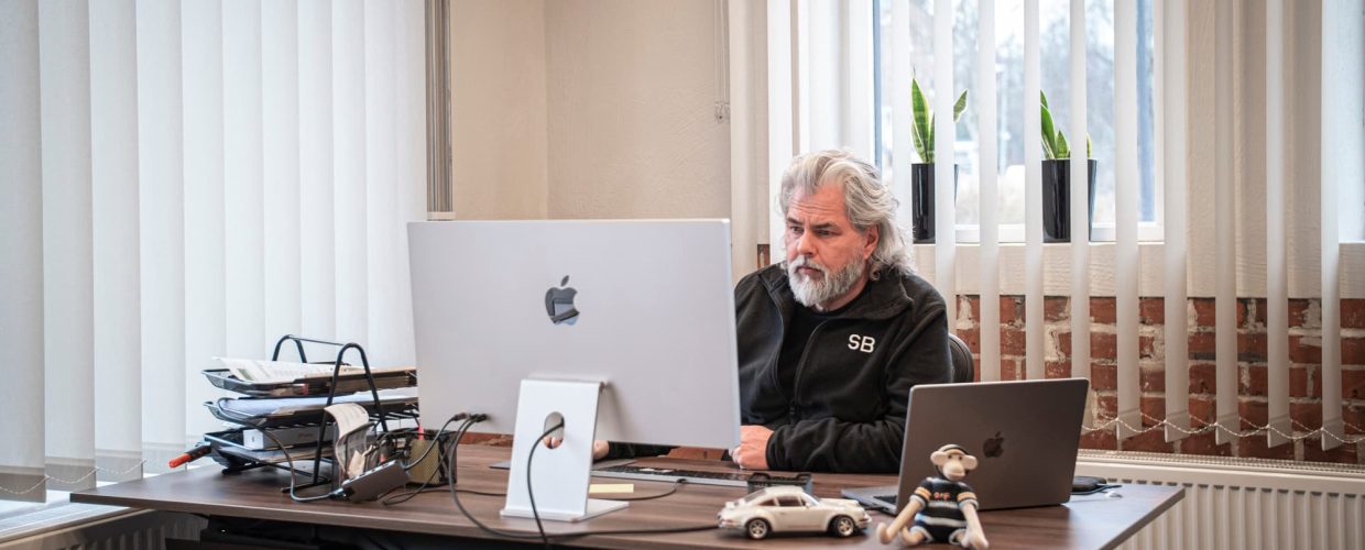 Kontor med ljusinsläpp i två väderstreck. Vd Stephan Burman sitter vid ett skrivbord och arbetar framför en datorskärm.