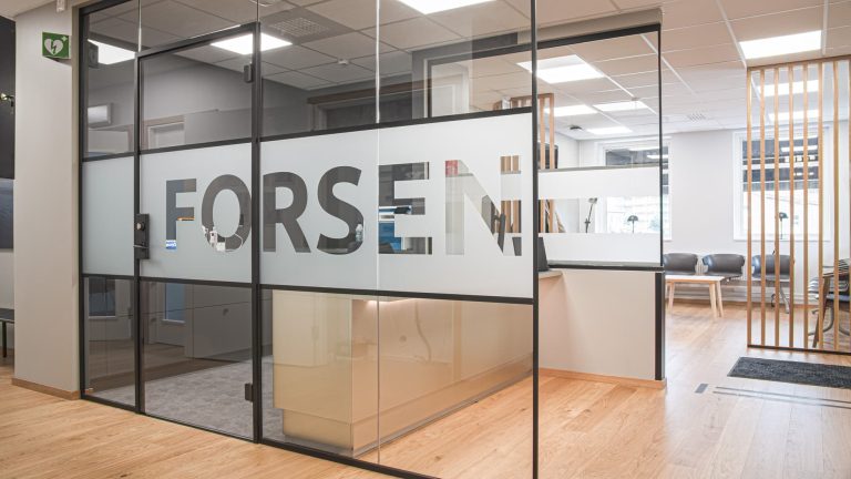 Receptionsdisk på Forsen vårdcentral. Frostat glas med utskuret för namnet Forsen